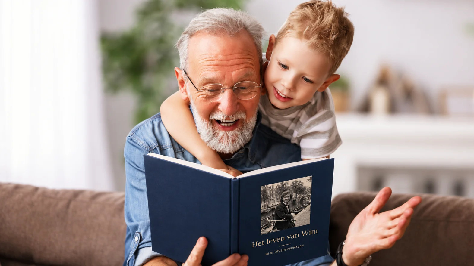 Een opa leest met zijn kleinzoon op de bank in zijn Mijn Levensverhalen-boek